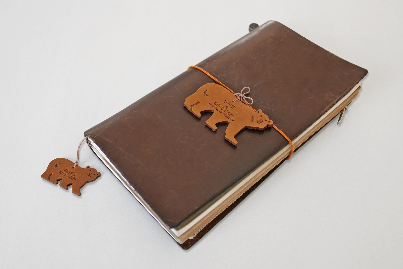 TF Holiday leather tag bears secured on a TRAVELER'S notebook.