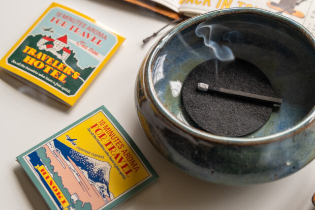 Hibi incense burning in dark green ceramic bowl beside the TRC x hibi incense match packaging.