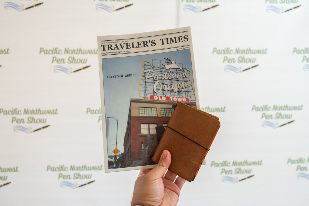 A TRAVELER'S notebook passport size with a TRAVELER'S TIMES against a white background.