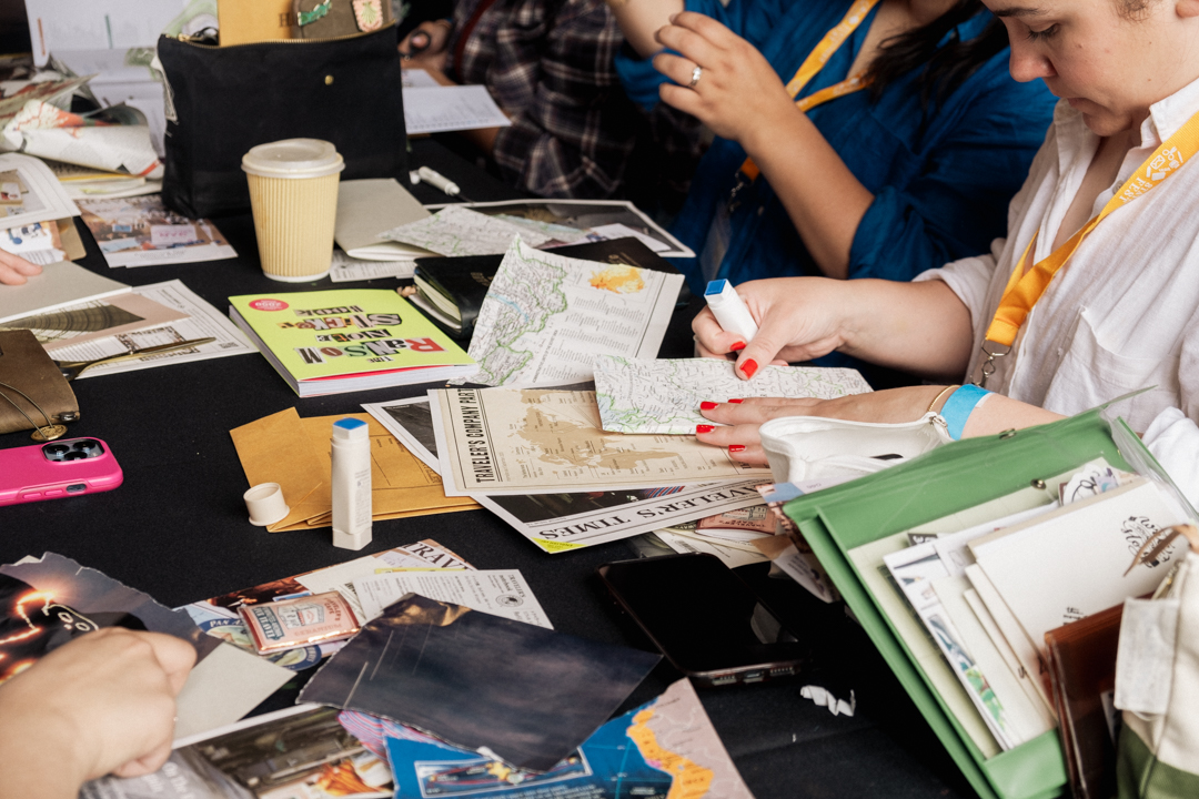 TRAVELER'S notebook users at a workshop journaling, collaging, and creating art together at a white table.