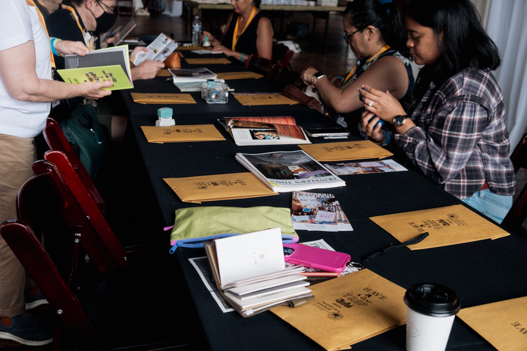 TRAVELER'S notebook users at a workshop journaling, collaging, and creating art together at a white table.