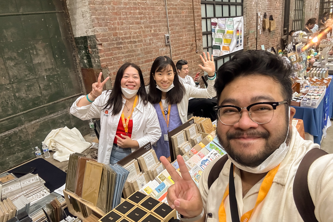 TRC USA staff taking a selfie in front of the TRC USA booth at Stationery Fest.