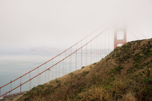 San Francisco's Golden Gate Bridge peeking from behind the hill.