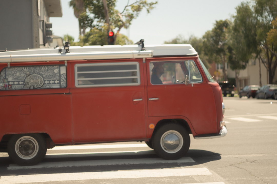 A red van turning into an intersection on the road.