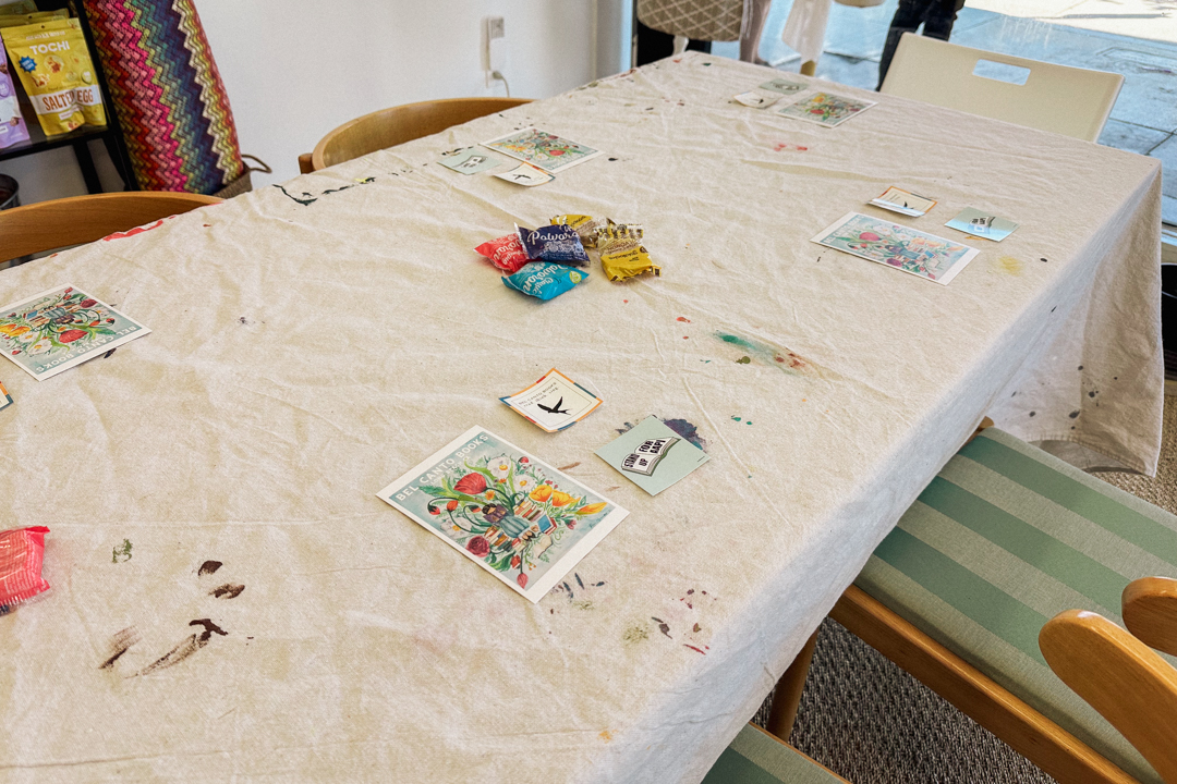 Table with table cloth and different free goods made by Bel Canto Books for the TRC USA TRAVELER'S notebook meet-up.