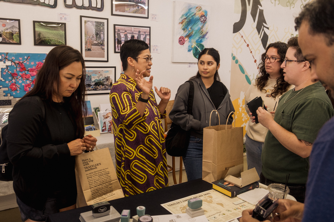 People chatting and stamping their notebooks in the KUBO LB store.