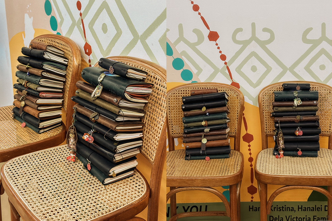 TRAVELER'S notebook stacked up on top of each other on top of a rattan chair.