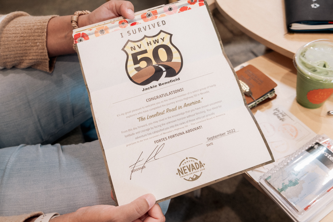 Person holding a " I Survived NV HWY 50" certificate. 