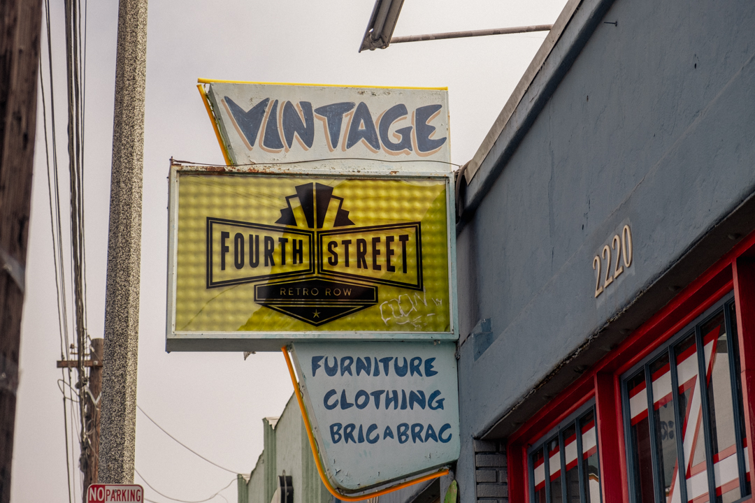 A neon sign of a vintage store on 4th Street.