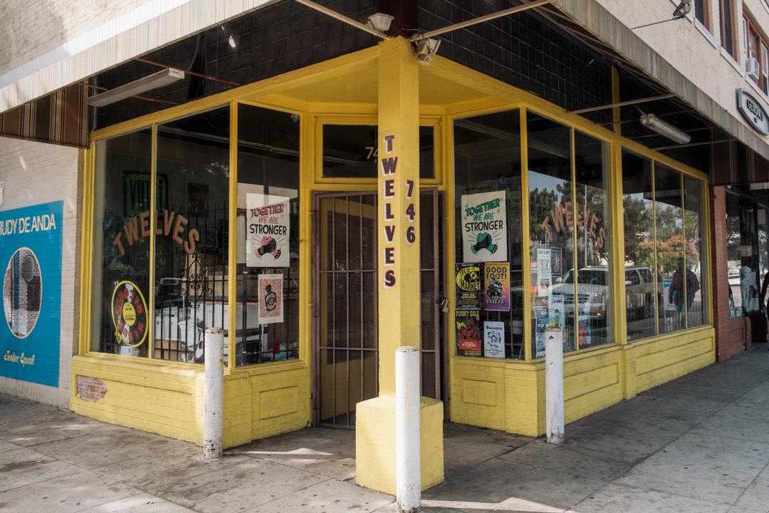 The entrance to Twelves Record Store with a yellow paint storefront.