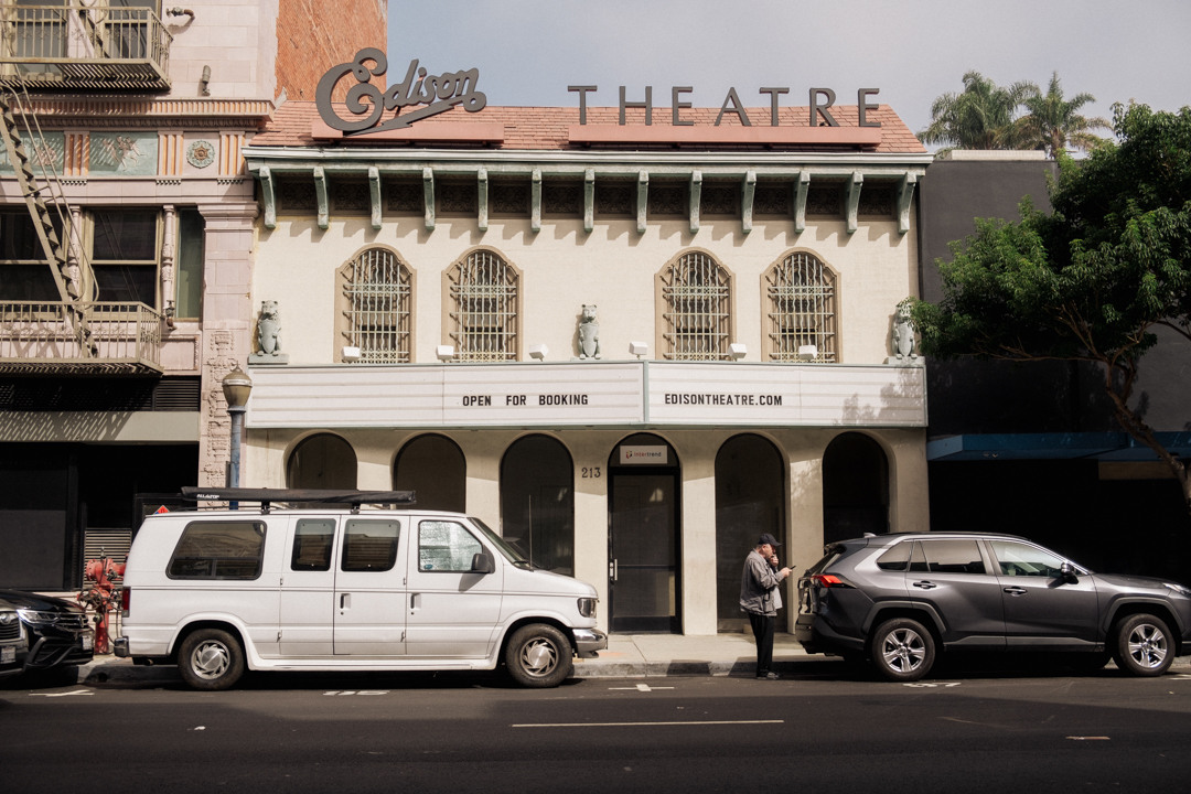 a van and car parked outside the Edison Theatre.