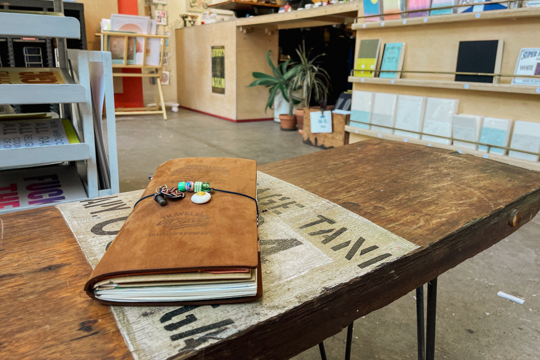 A TRAVELER'S notebook resting on a table inside The Aesthetic Union.