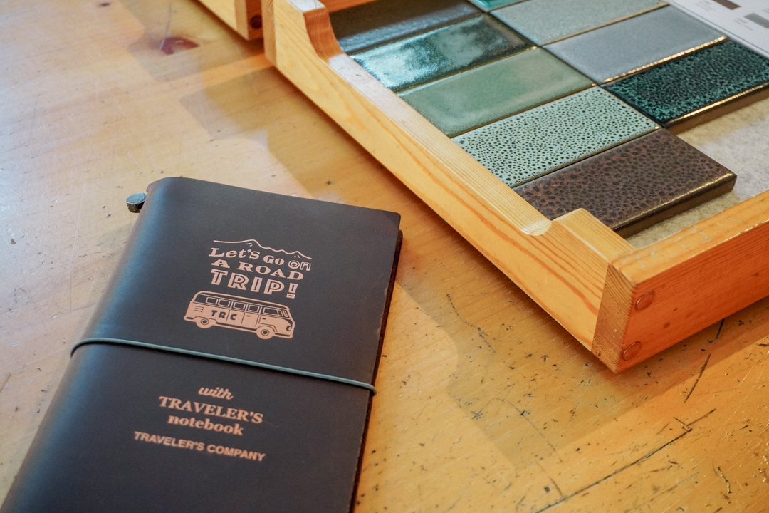 TRAVELER'S notebook USA Road Trip Edition against a tray of tiles by Heath Ceramics.