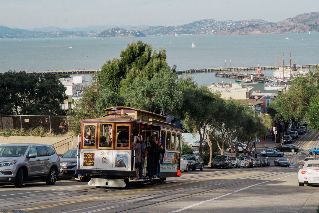 San Francisco's cable car against the view of the bay.