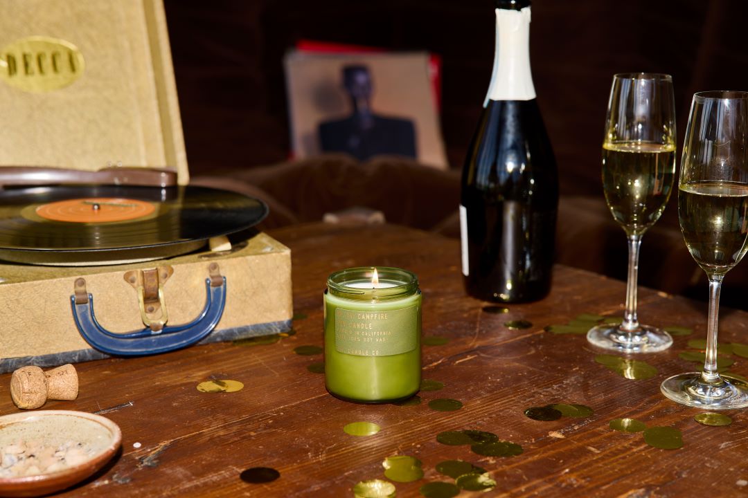 P.F. Candle Co. candles on a table with record player and champagne glasses.