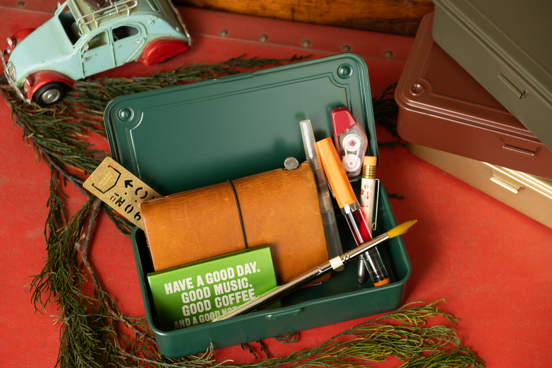 A Toyo Steel toolbox holding TRAVELER'S notebook, Art Toolkit Pocket Palette, pens, and other tools.