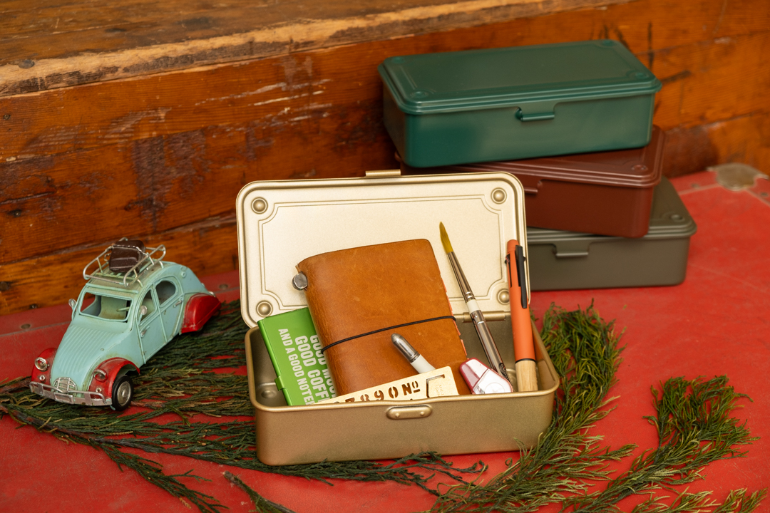 Four colors of Toyo Steel Toolboxes holding TRAVELER'S notebook and other tools.