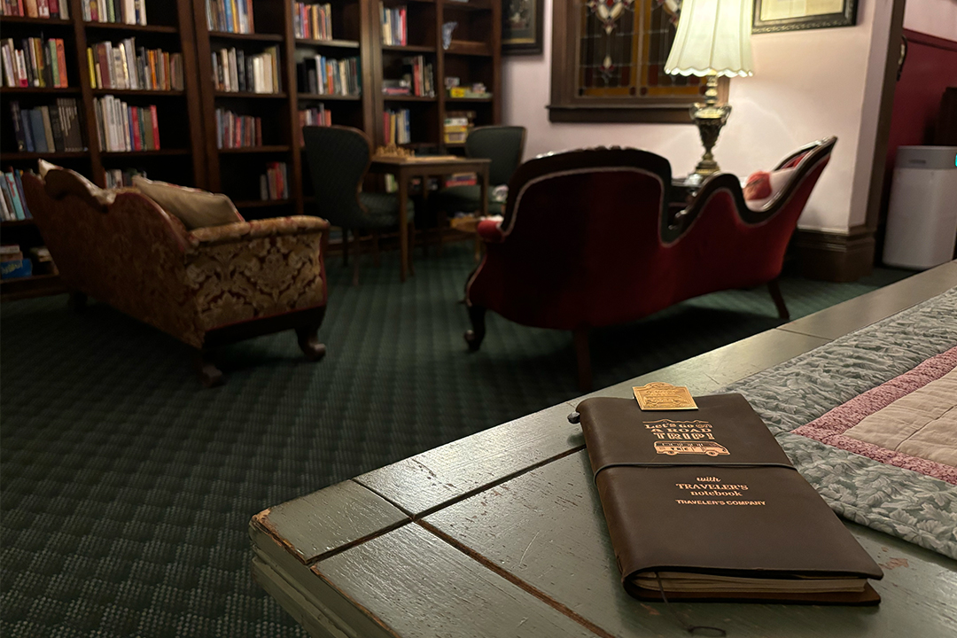 TRAVELER'S notebook on a table in a vintage Victorian-style room.