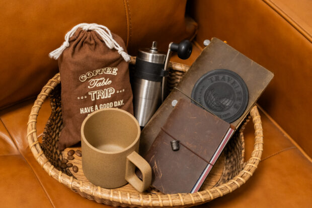 A basket filled with TRAVELER'S notebook, TF Original Coffee Bag, PORLEX Grinder, and a HASAMI CERAMICS Mug.