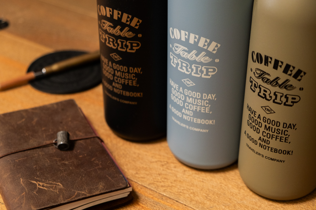 Three colors of TF Stainless Steel Bottles with a TRAVELER'S notebook Passport Size.