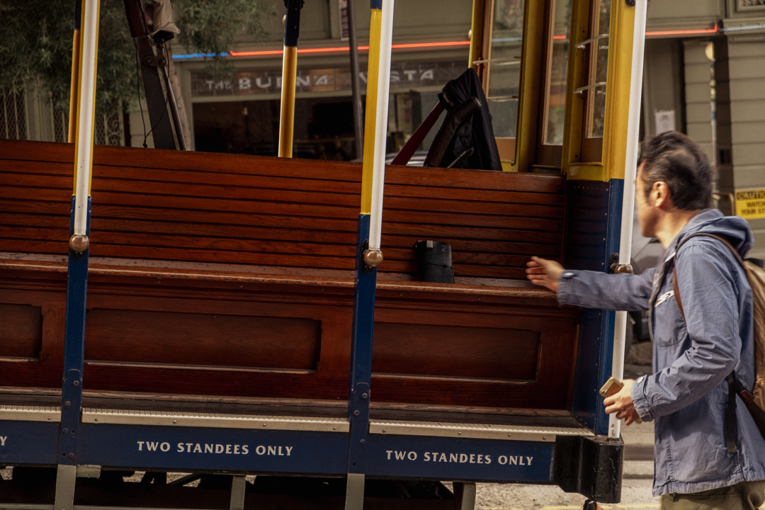 Person putting a TRAVELER'S notebook on a street car.