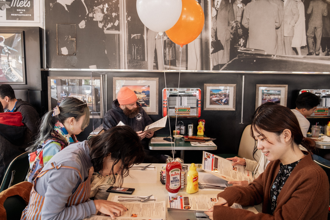 People at Mel's Diner eating and enjoying traditional diner food.