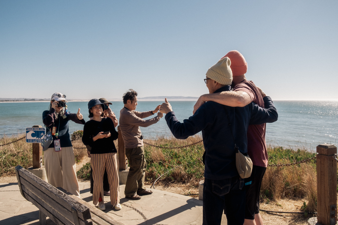 Candid photo of people posing for a photo near the oceanside cliff.