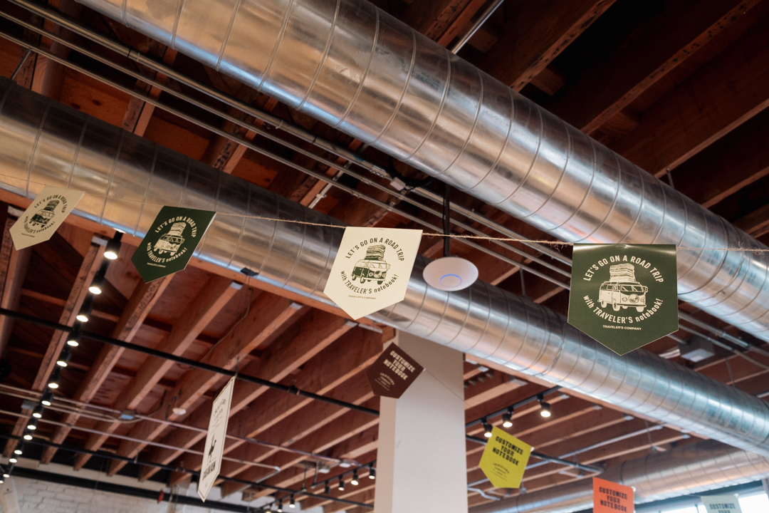 Flag banners hanging from the ceiling of an industrial building.