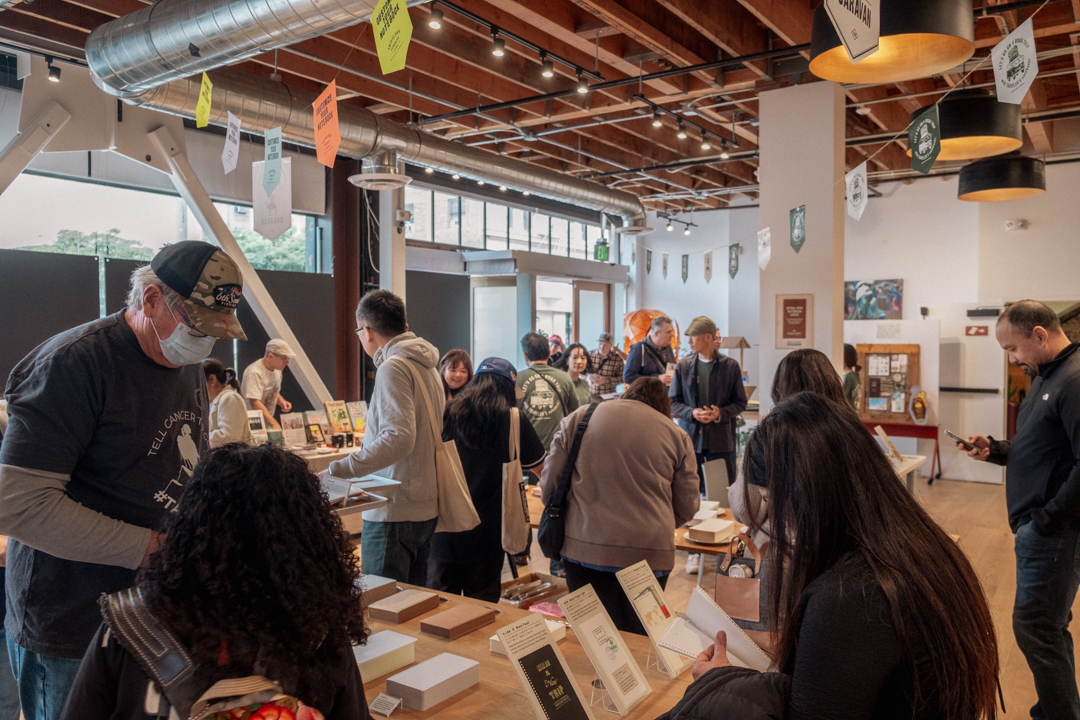 People choosing different papers on the wooden table to assemble their custom spiral ring notebook.