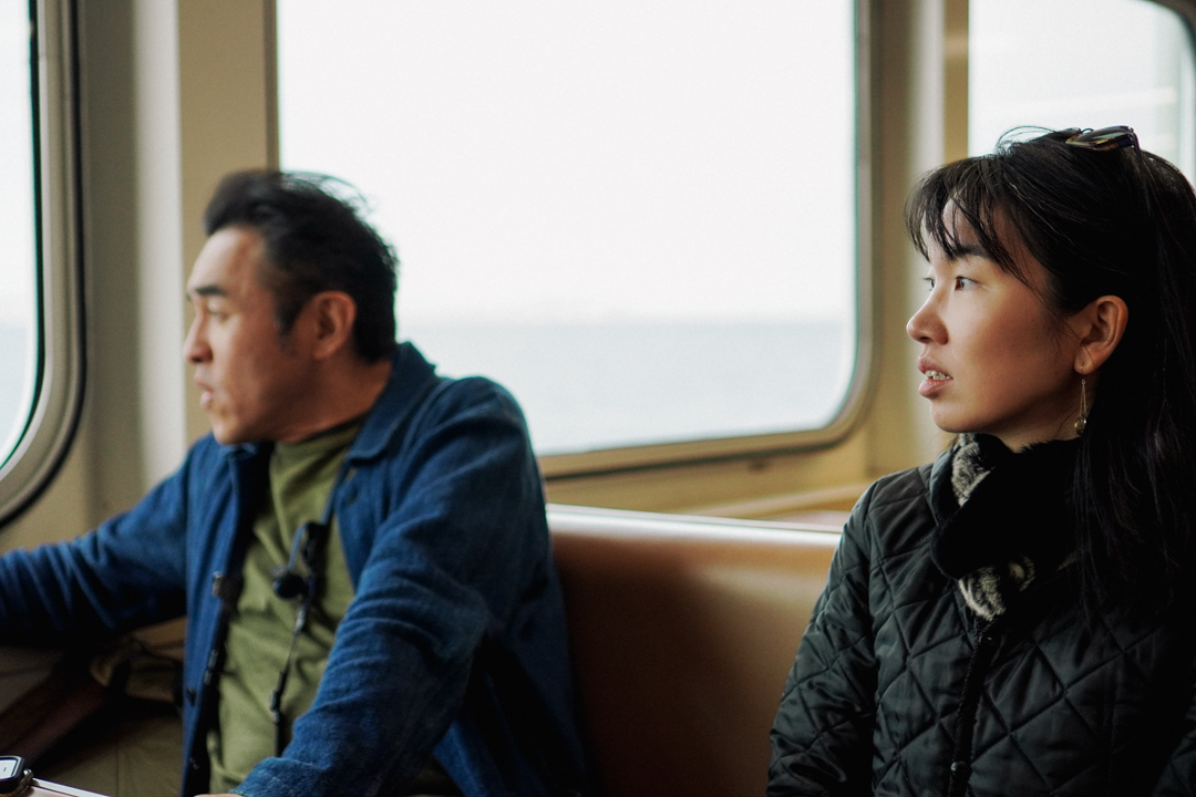 Two people on the ferry looking out the window.