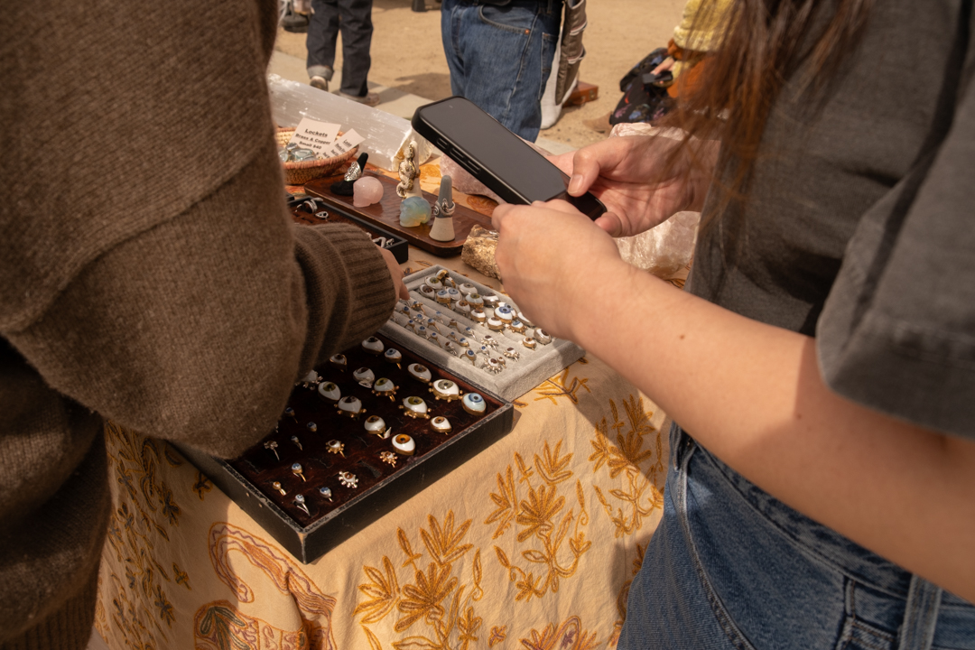 Customers looking at handmade rings at an artisan fair.