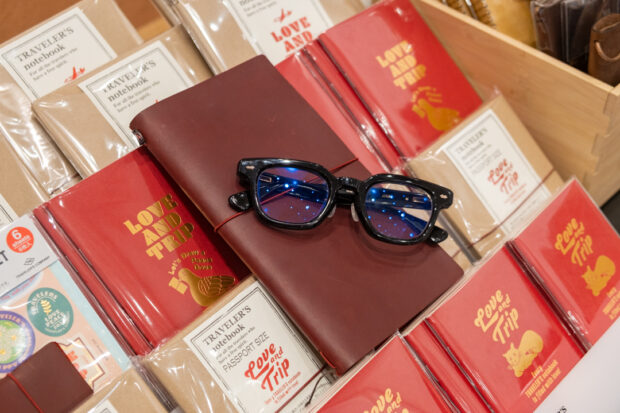 JINS glasses on top of the LOVE AND TRIP red TRAVELER'S notebook.