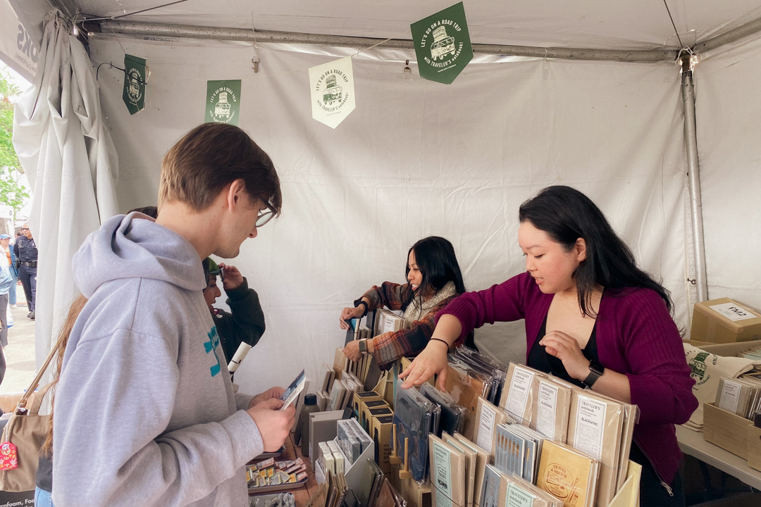 People shopping at the TRC USA booth at the L.A. Times Festival of Books while the TRC USA staff other customers. 