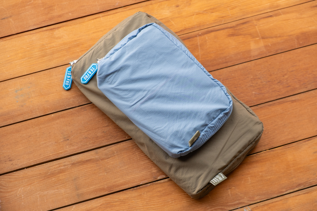 TO&FRO Organizer in Olive and Blue Gray in a Regular and Passport Size TRAVELER'S notebook on a wooden table.