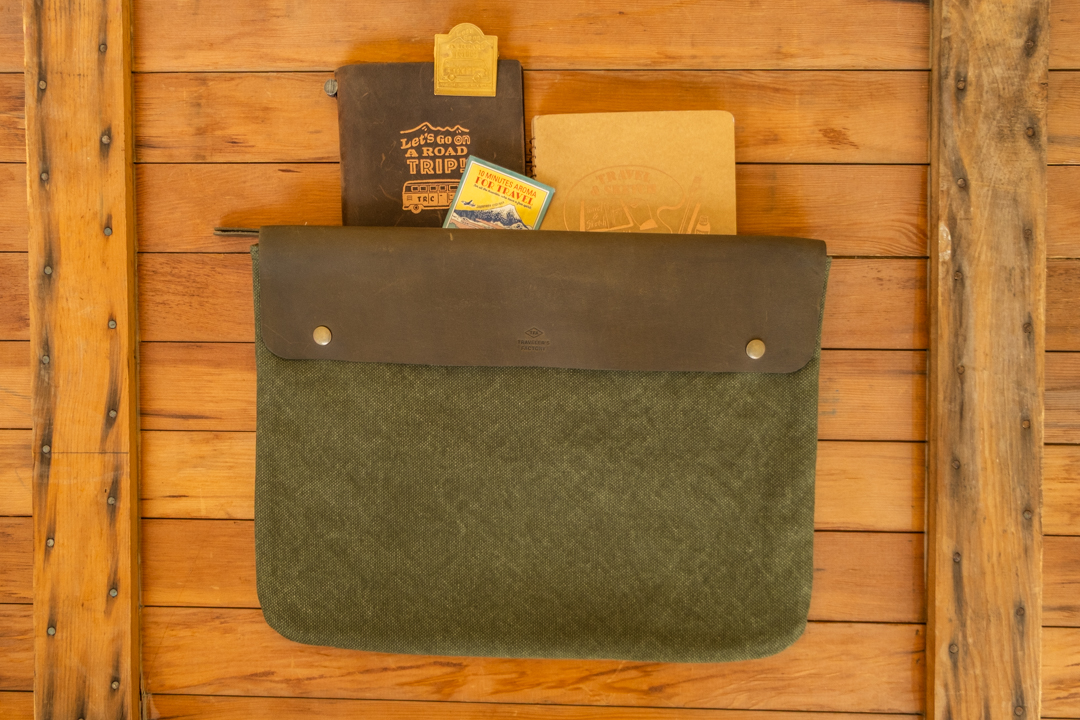 The TRAVELER'S FACTORY Canvas pouch in olive L size with stationery inside it.