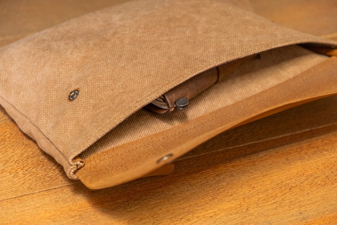 The TRAVELER'S FACTORY Canvas pouch in beige M size opened to fit a Passport  Size TRAVELER'S notebook.