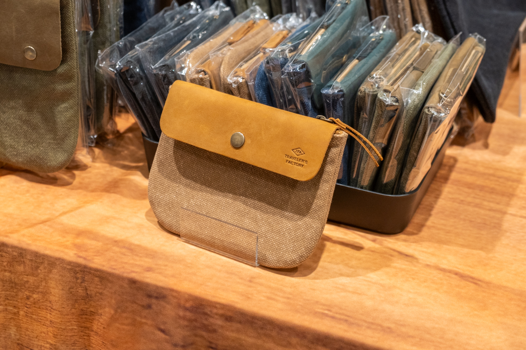 The TRAVELER'S FACTORY Canvas pouch in beige in S size is displayed at the TRC USA vendor table.
