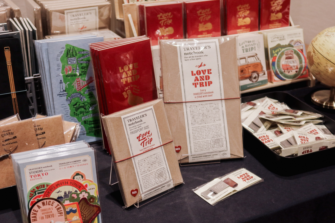 TRC items like the LOVE AND TRIP red TRAVELER'S notebook at the TRC USA table at Little Craft Fest.