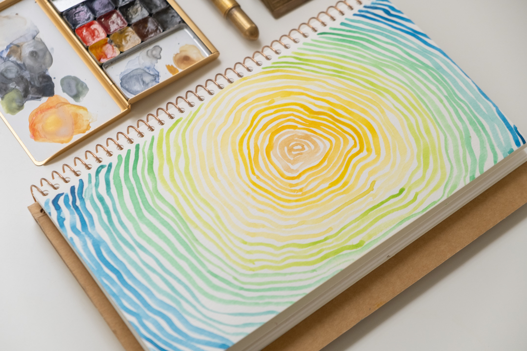 A painting of co-centric tree rings using watercolor on the TRC USA Limited TRAVEL & SKETCH SPIRAL RING NOTEBOOK.
