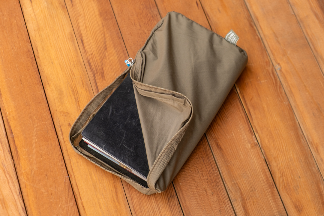 A TO&FRO TRAVELER'S notebook organizer (Regular Size) in Olive holding a black TRAVELER'S notebook.