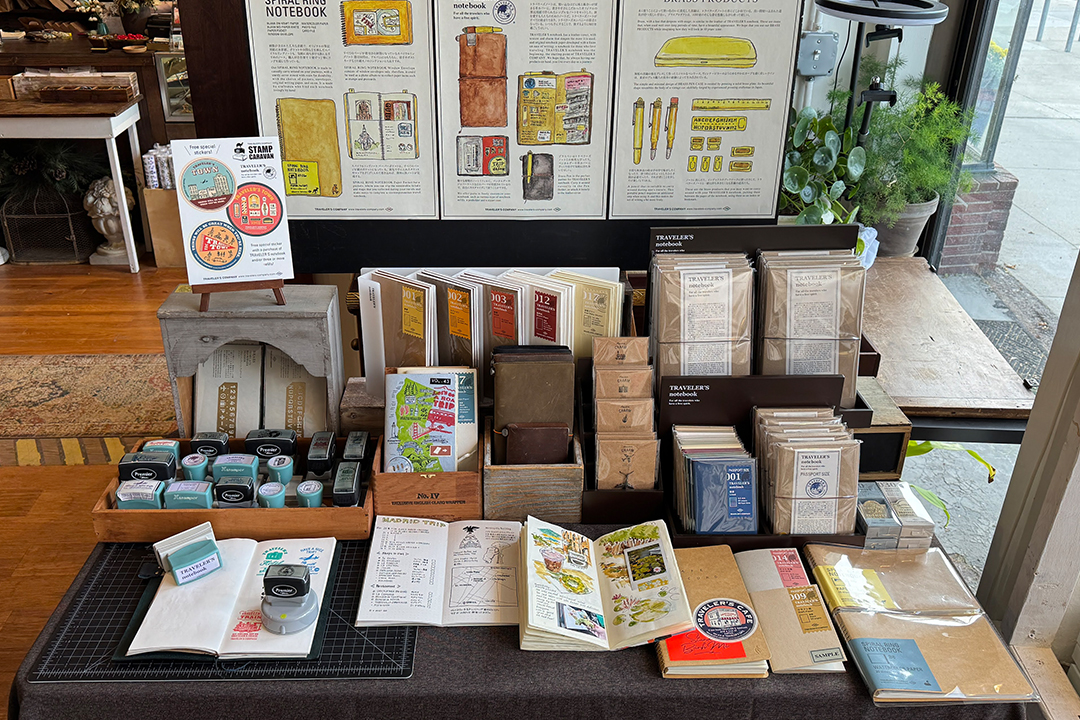 TRAVELER'S COMPANY items displayed next to the Stamp Caravan experience.