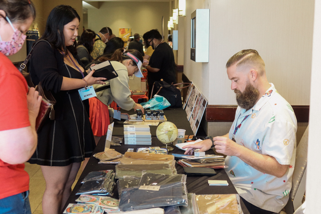 A person ringing up a customer's TRC USA purchases at the SF Pen Show.