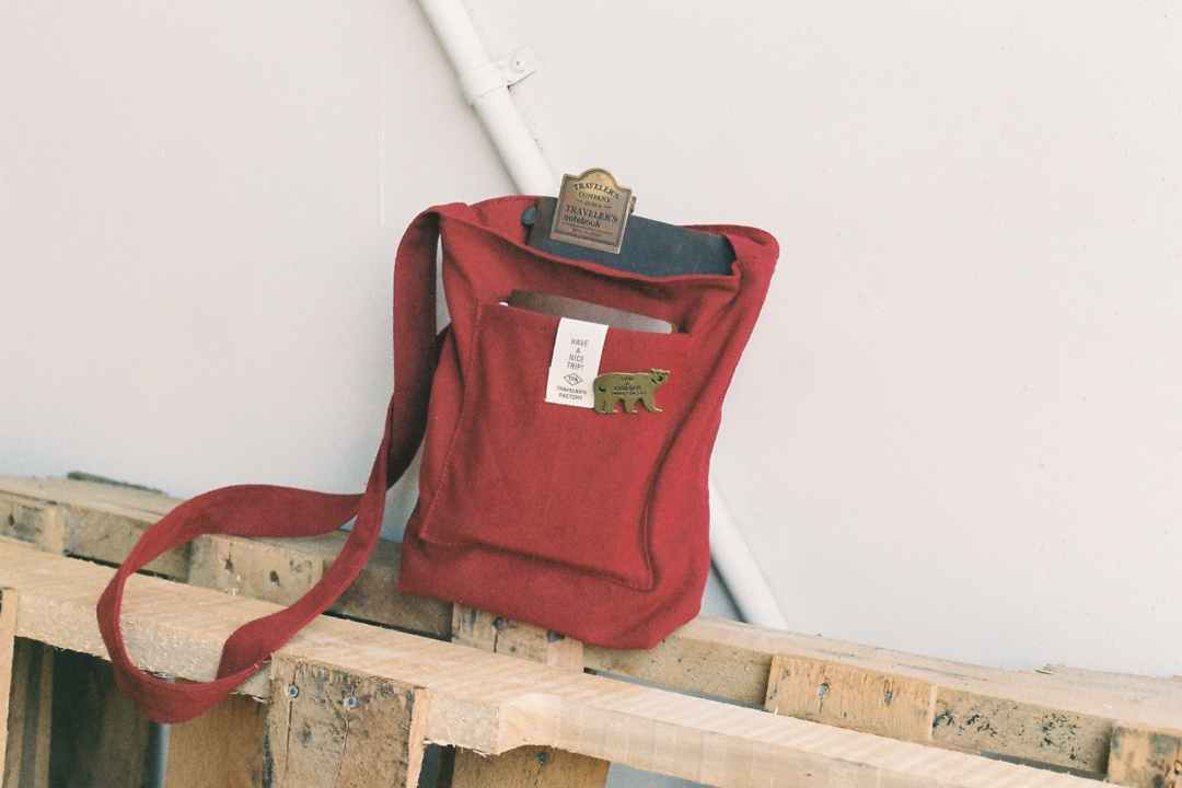 A red sacoche with a TRAVELER'S notebook inside.