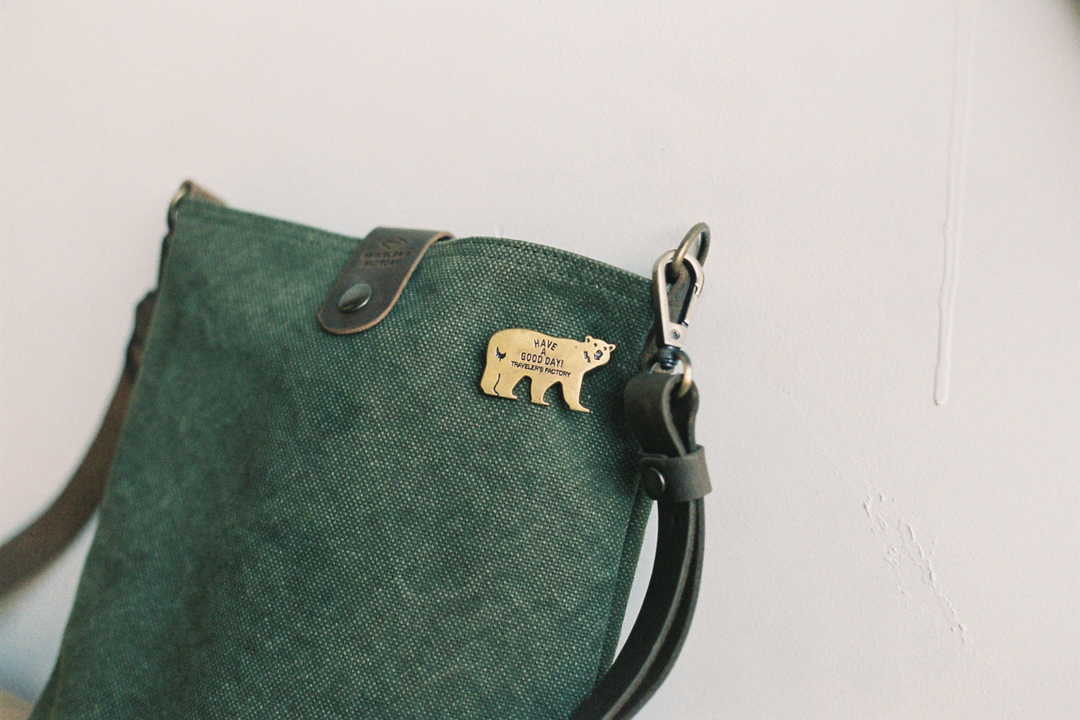 TF Brass badge bear pinned on a Canvas Shoulder Bag.