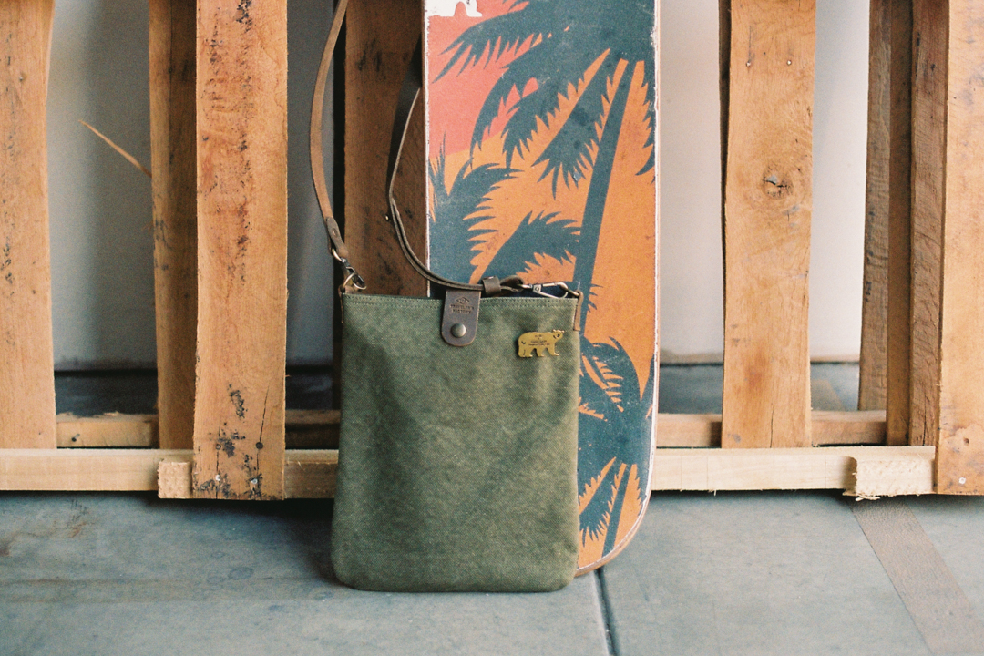 TF Canvas Shoulder Bag S next to a skateboard.