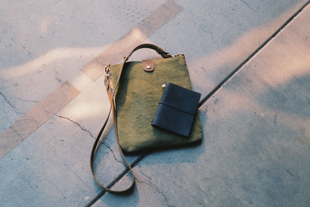 A TF Canvas Shoulder Bag S with a TRAVELER'S notebook passport size next to it.