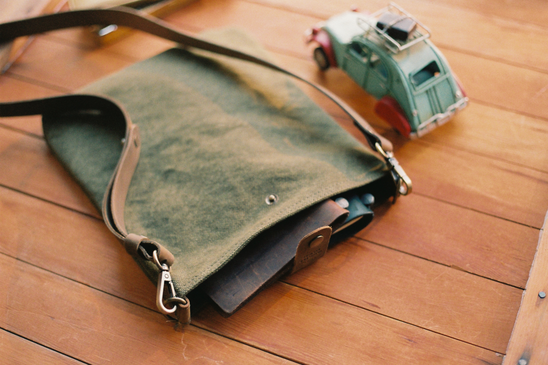 TF Canvas Shoulder Bag S in Olive with a TRAVELER'S notebook inside.