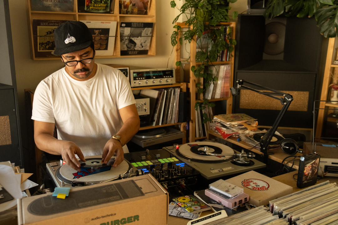 TWELVES RECORD Shop owner Hector places a record on a record player.