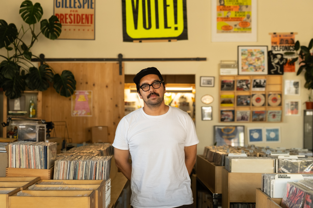 Shop owner Hector Waluyo standing inside TWELVES RECORD.