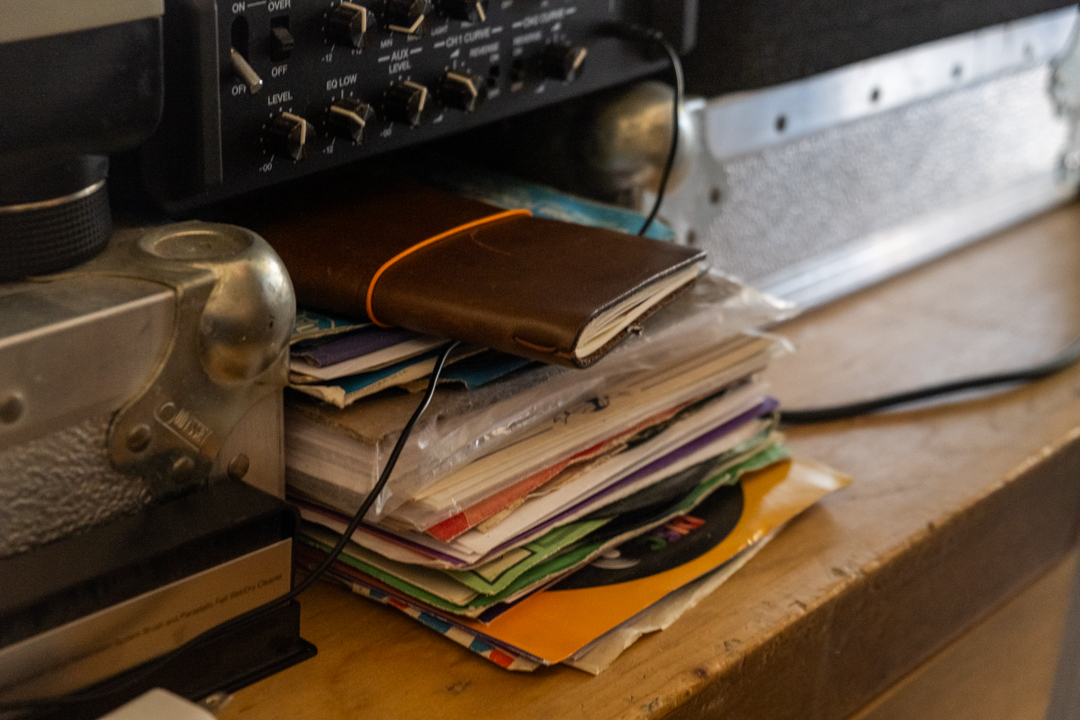 A TRAVELER'S notebook resting on a stack of 7" records.